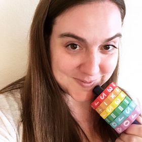 Headshot of site creator, Kim, holding math toy close to her face and smiling